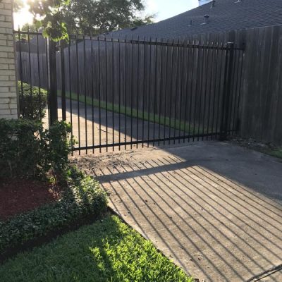 residential-iron-gate-4-p1lyhoon2662yjis6y4jev6kihyn21nrkwzbv1gd5s - Mustang Fencing and Gates A modern residential iron gate with geometric design, installed by Mustang Fencing and Gates.