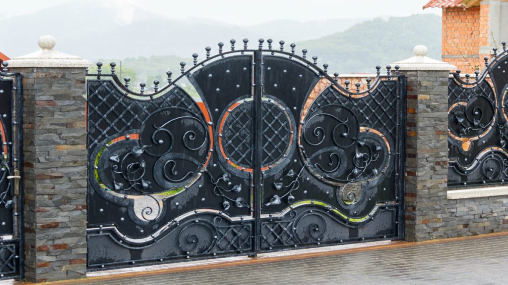 What-is-the-Difference-Between-a-Wrought-Iron-Gate-and-a-Steel-Fence-1200x675 - Mustang Fencing and Gates A comparison between a wrought iron gate and a steel fence, showing the differences in design and material.
