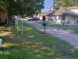 "Chain link fence gate in a yard in Houston, Texas, provided by Mustang Fencing and Gates."