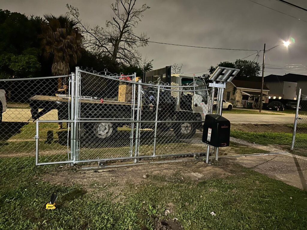 houston texas chain link gate fence nighttime - Mustang Fencing and Gates "Chain link gate and fence in Houston, Texas, illuminated under the night sky."