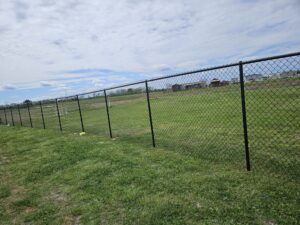 "Chain link fence in a field in Houston, Texas, provided by Mustang Fencing and Gates."