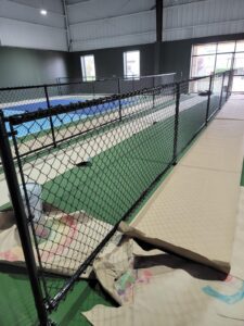 "Indoor chain-link fence installation in Houston, TX by Mustang Fencing and Gates."