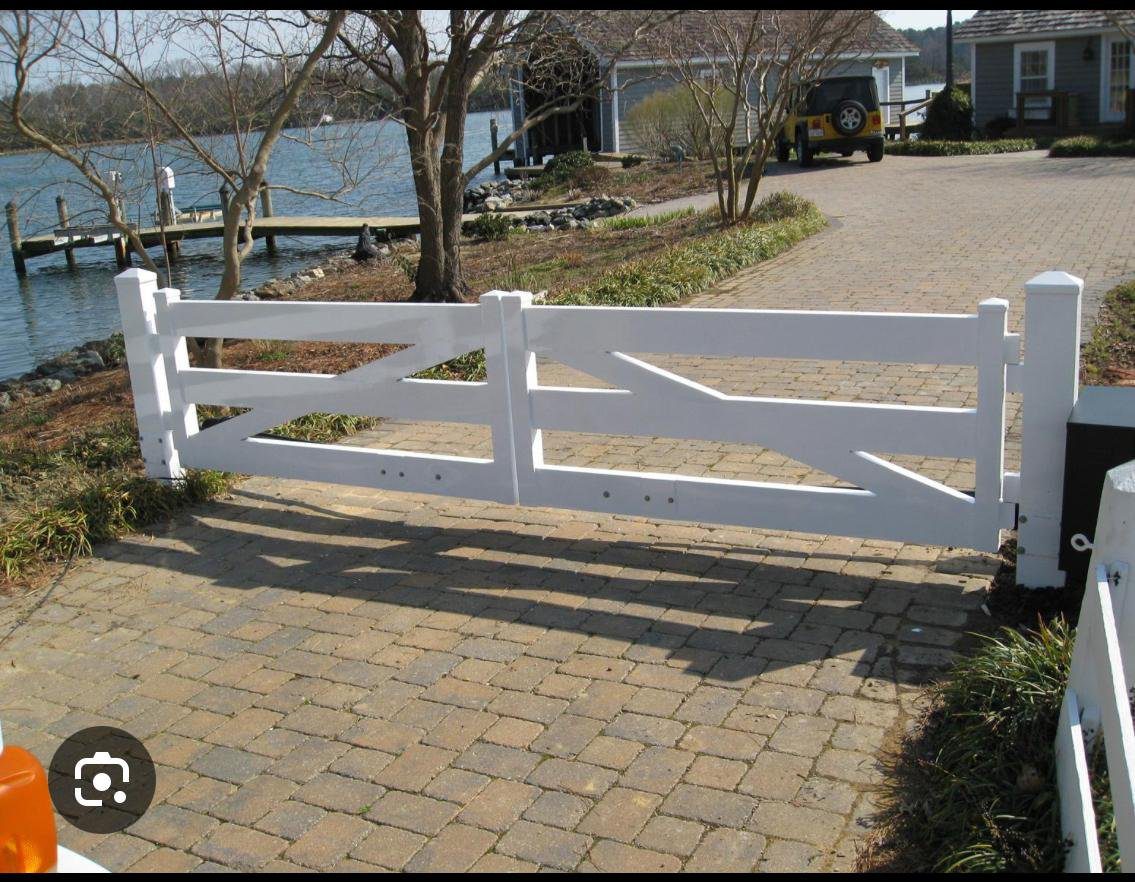White three-rail ranch fence and wood gate on a Houston-area acreage