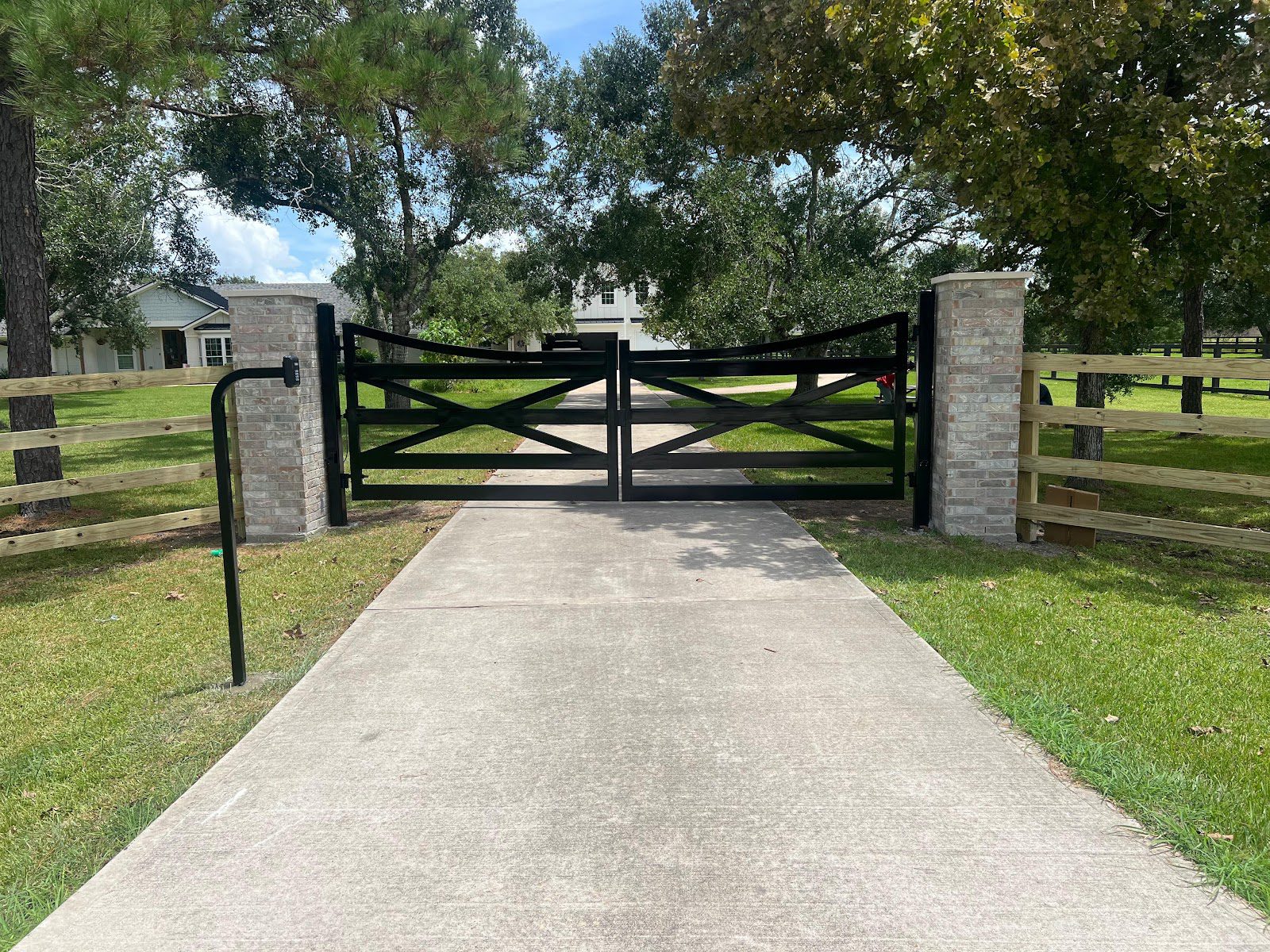 A dedicated keypad entry station governs code-based access at a controlled driveway gate between masonry columns.