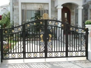 A black wrought iron main gate with intricate design and scrollwork, installed by Mustang Fencing and Gates.