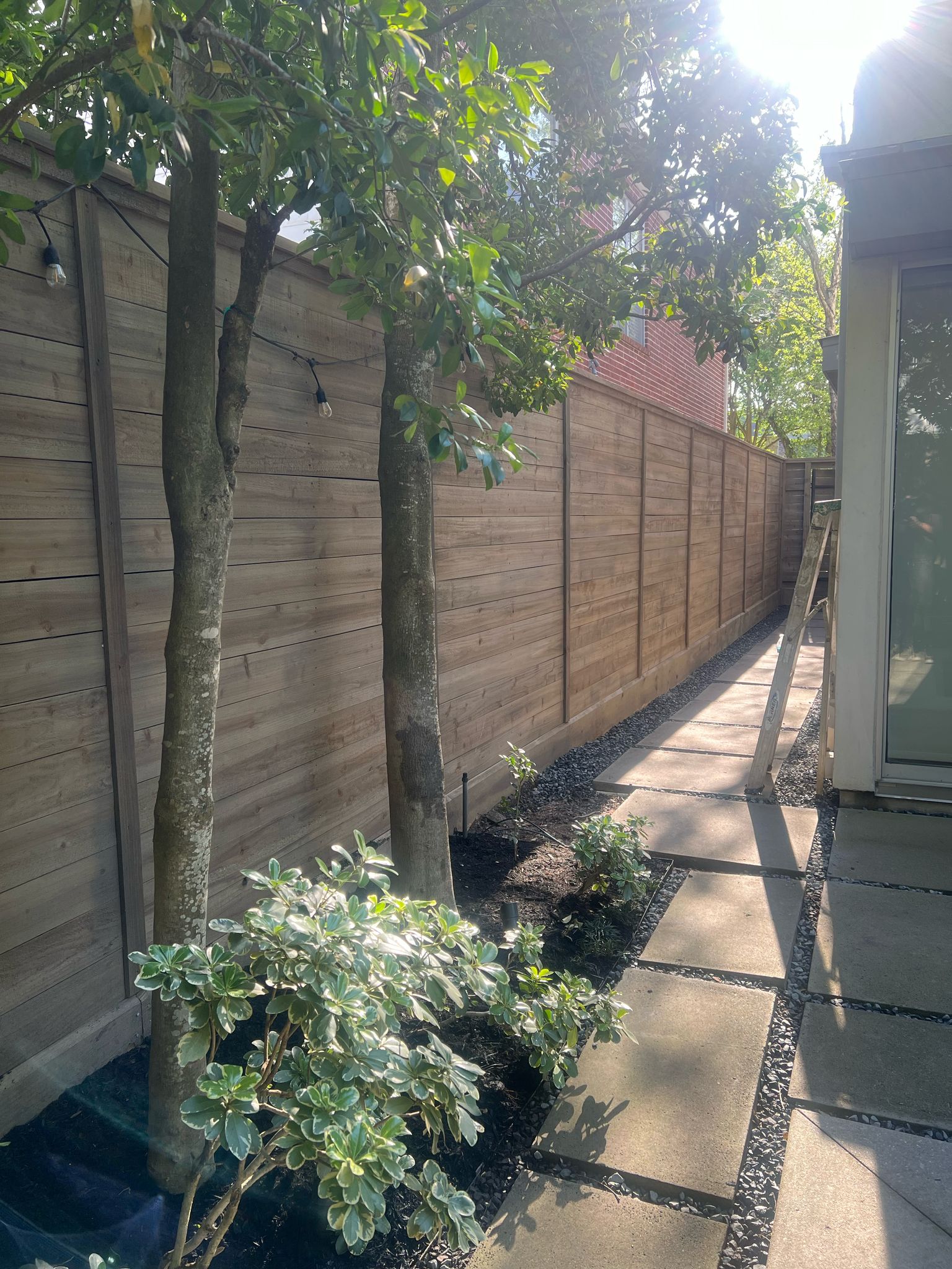 Wooden privacy fence lining a Houston garden pathway by Mustang Fencing and Gates